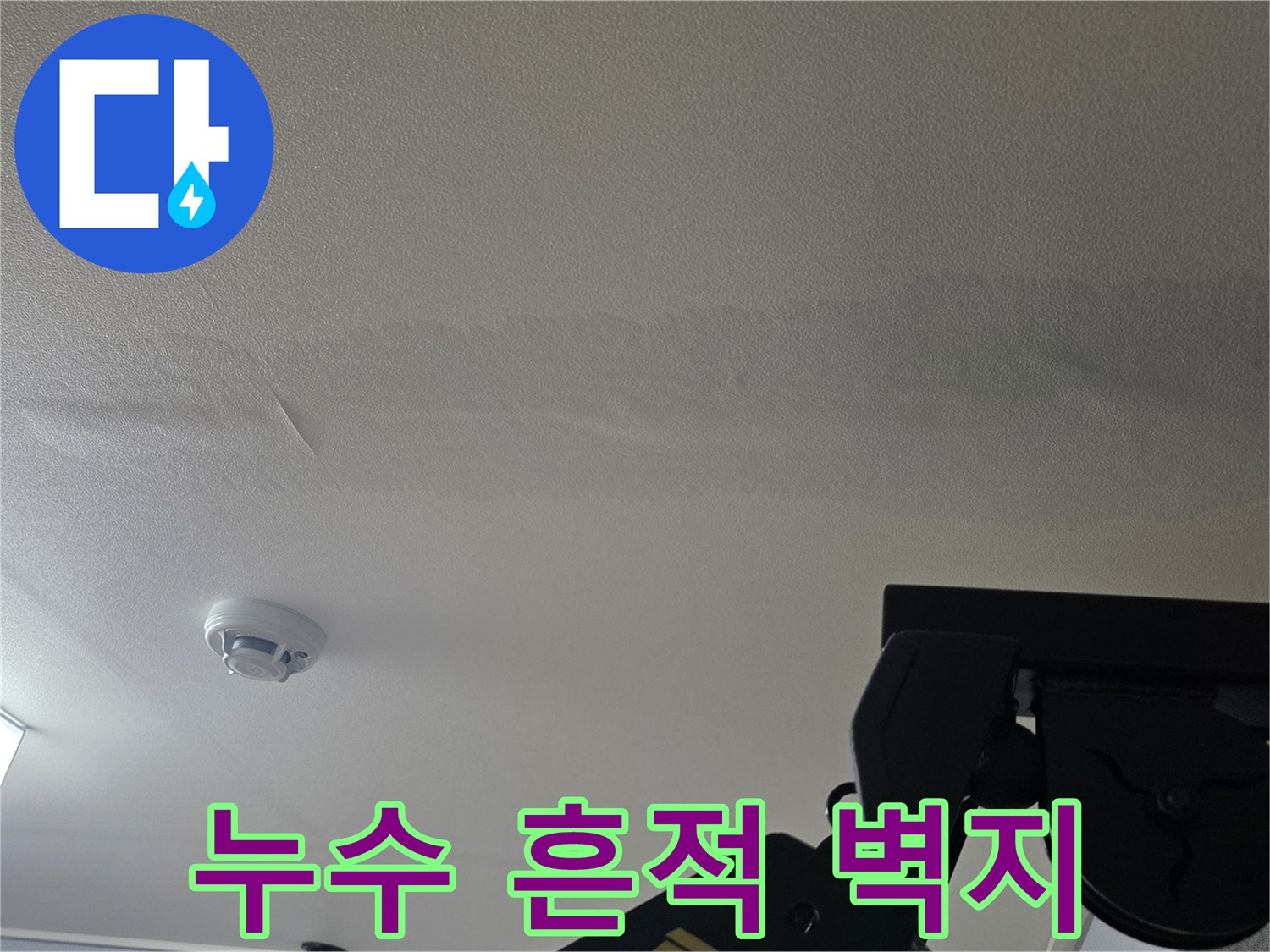 천장 벽지에 스며든 수분과 변색된 얼룩 부위