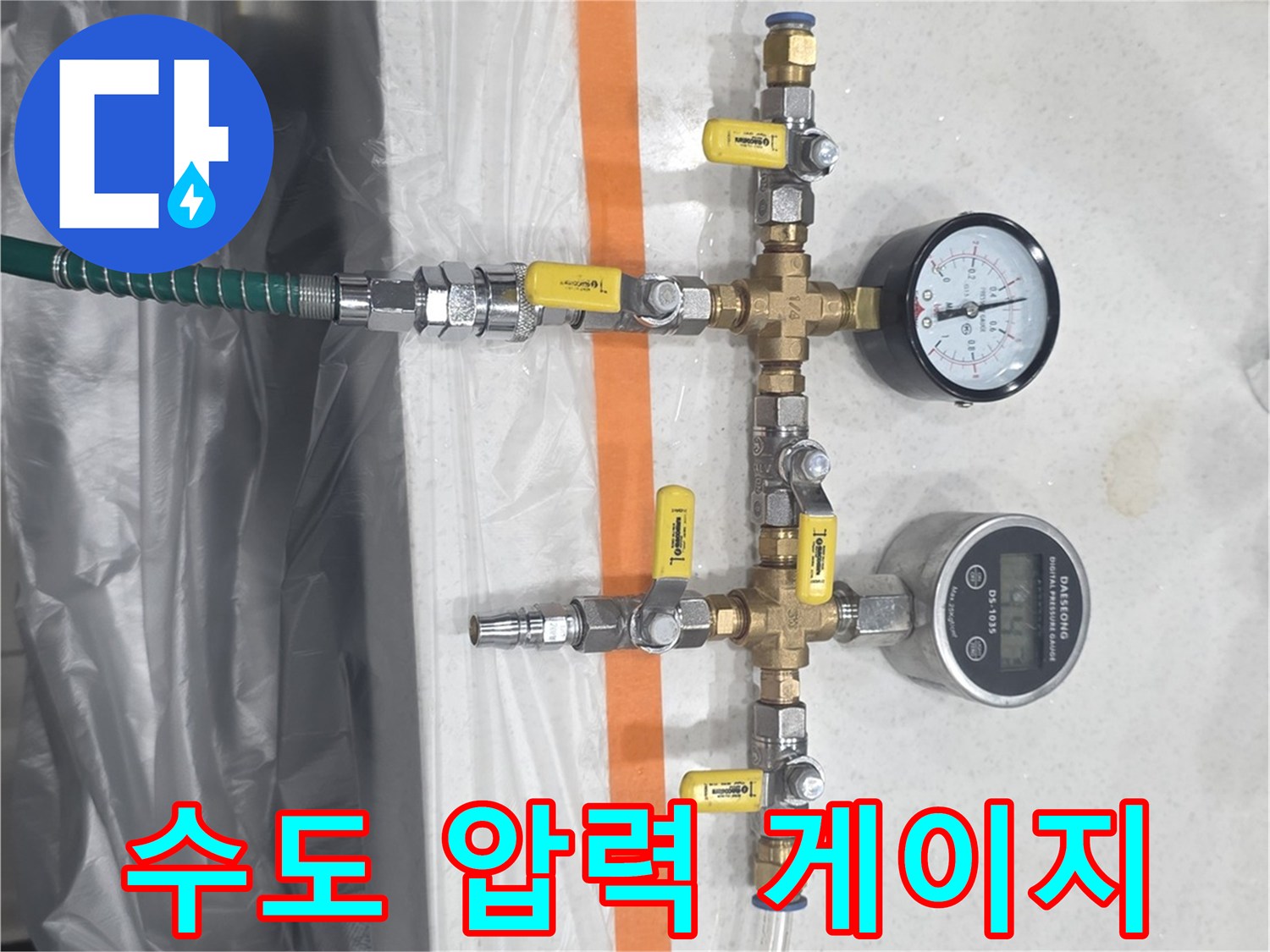 배관 분기점에 설치된 두 개의 수압 측정용 게이지와 연결 호스
