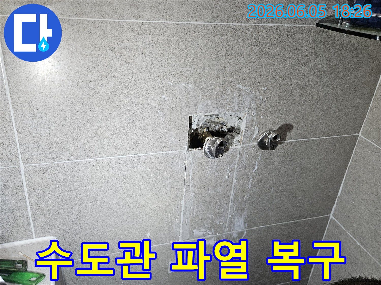 주택 욕실 벽면 내부에서 파열된 수도관을-신속하게 복구하고 있는 전문 기술자의 작업 현장