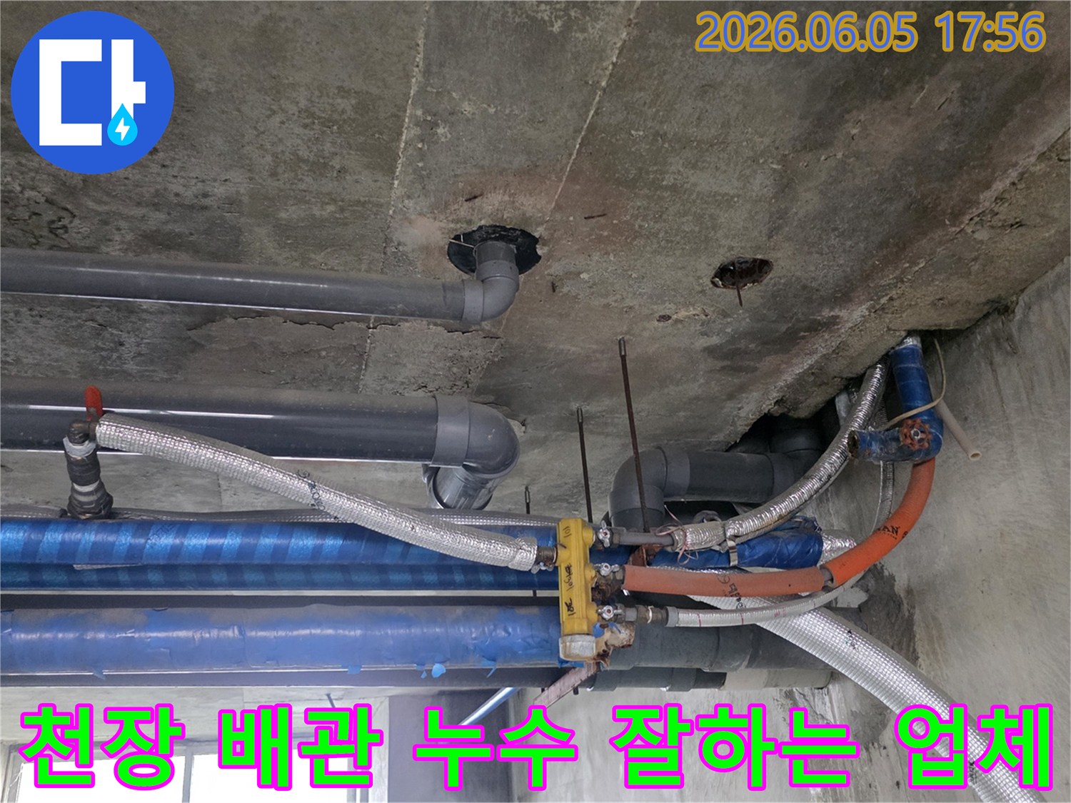 콘크리트-천장-아래-설치된-다양한-배관들의-복잡한-모습-누수-탐지-전문가가-현장을-면밀히-조사하고-있습니다