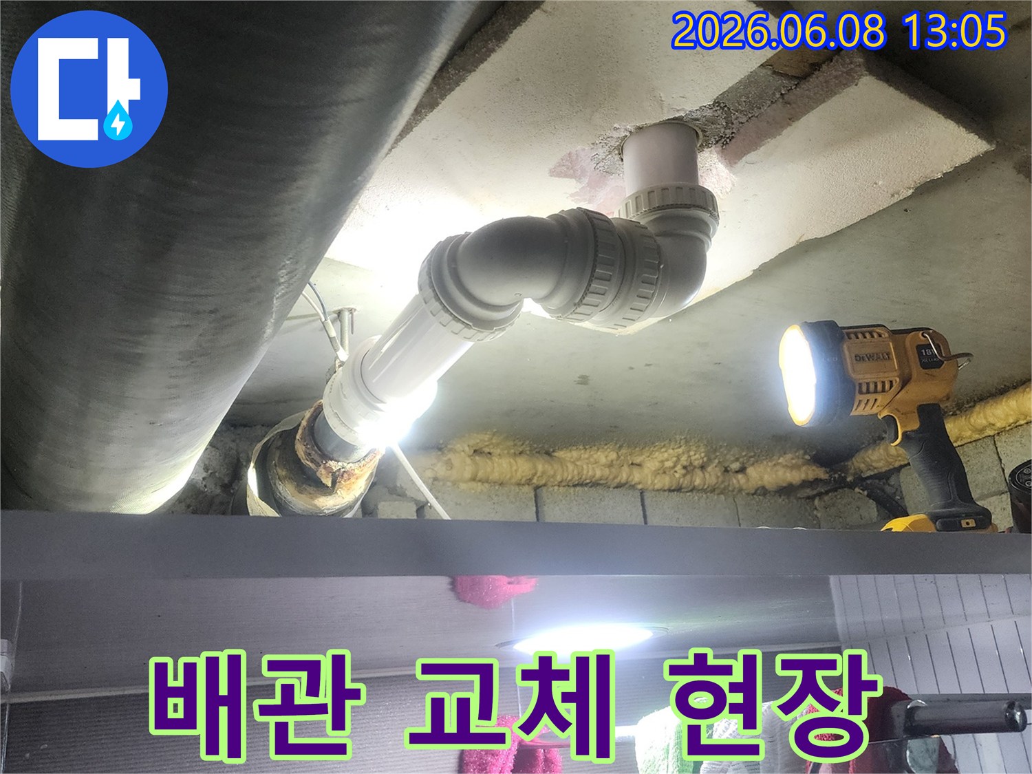 작업등으로 밝혀진 공간에서-배관 교체 작업이-진행되고 있는-장면입니다.