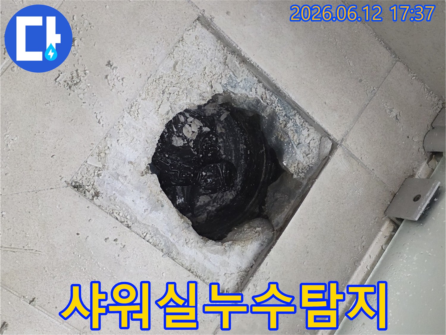 샤워실 바닥 배수구 주변의 타일을 제거하여-누수 원인을 탐지하는-숙련된 누수 전문가의 작업 현장입니다.