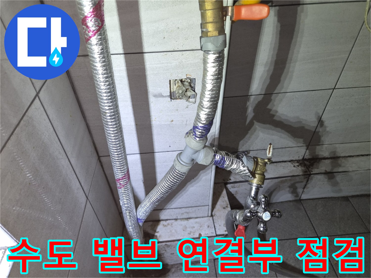 노후된 수도 밸브와 은색 보온재가 씌워진 배관의 결속 상태를 보여주는 사진입니다.