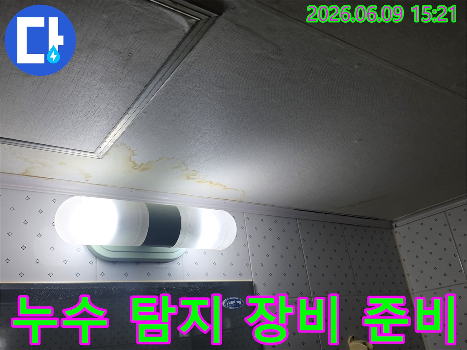 욕실 천장의-누수 흔적을-탐지하기-위해-전문 장비를-준비하는-모습을-촬영한-사진입니다