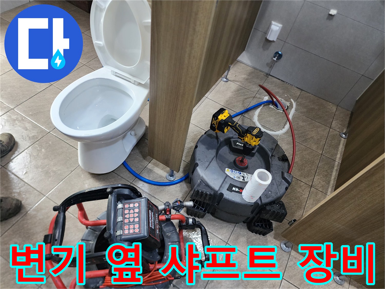 변기 옆에 설치된 배관 스케일링용 204 샤프트 장비와 전동 드릴