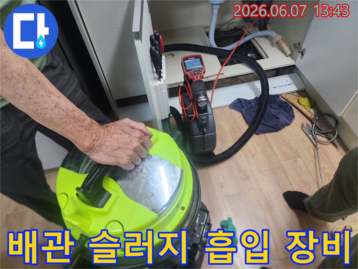 싱크대 하부장 바닥 배관-석션기를 사용하여 배관 속 이물질을 제거하고 있습니다.