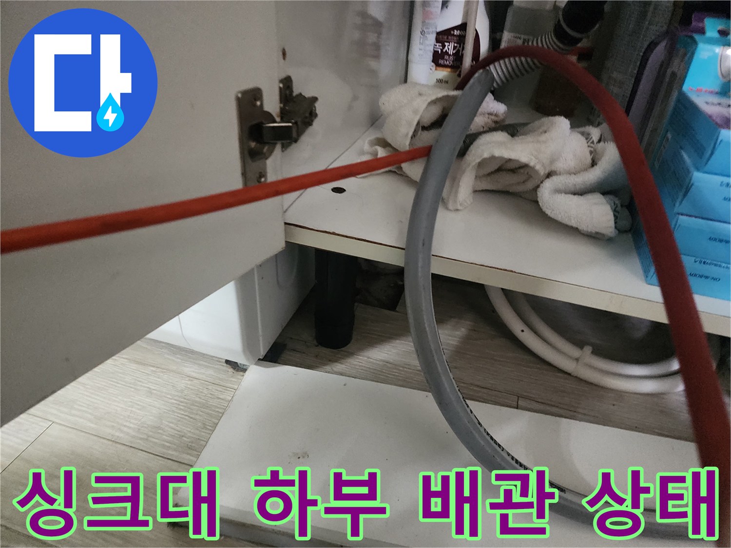 싱크대 하부장 내부의 배관 연결 부위와 장비들