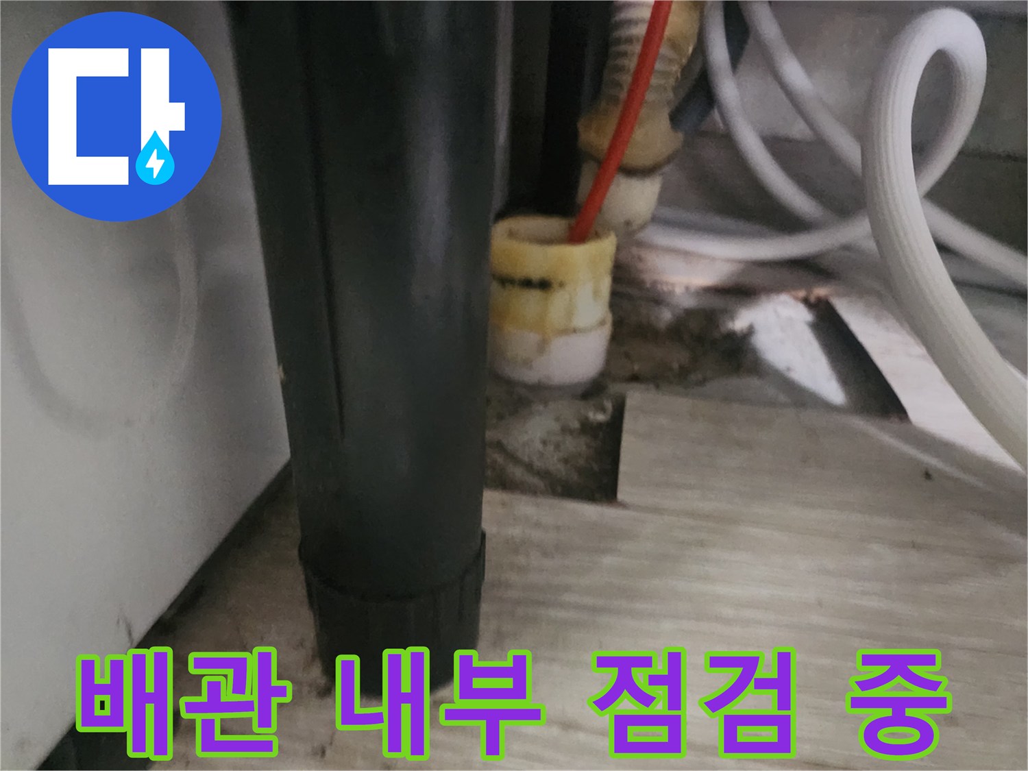주방 배관 입구에 삽입된 내시경 장비와 주변 구조물