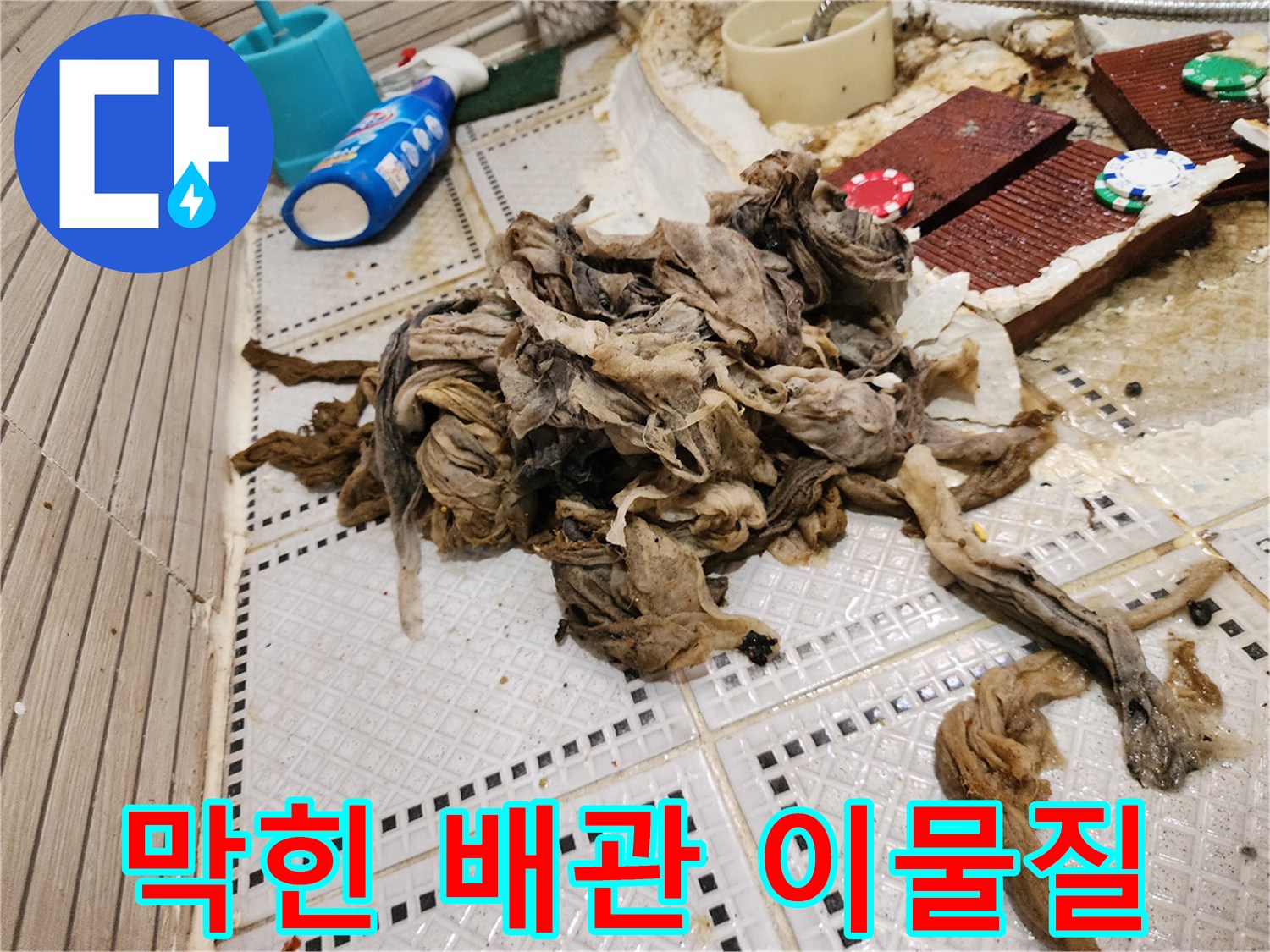 화장실 타일 위로 늘어진 거대한 머리카락과 오염 물질 뭉치