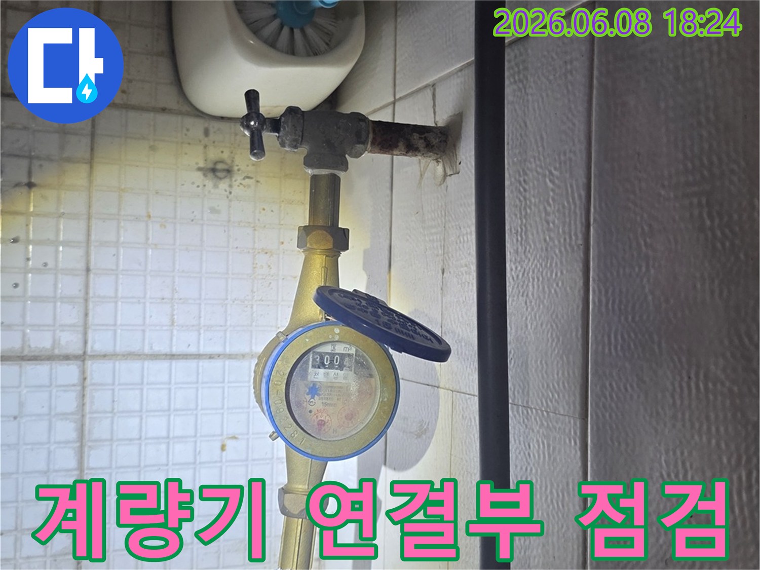 이 사진은-의정부 민락동에서-누수 엔지니어가-수도 계량기 연결 부위의-누수 여부를-정밀하게 점검하는-모습을-담고 있습니다