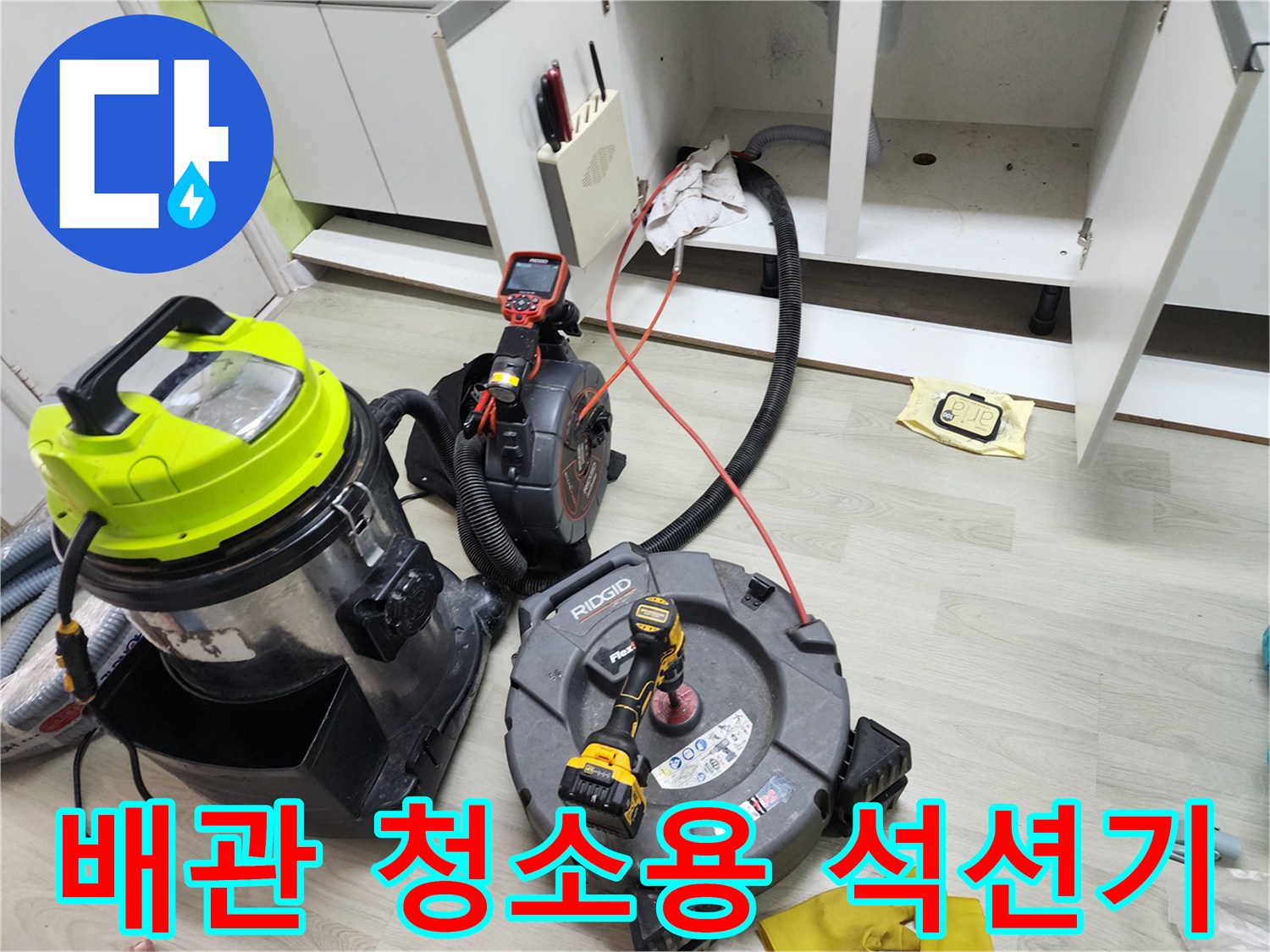 싱크대 아래 공간에 놓인 하수구 청소용 전문 장비들