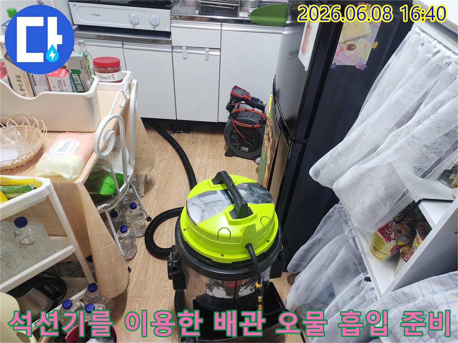 싱크대 하부 공간에 배치된 석션 장비와 작업 환경의 모습입니다.