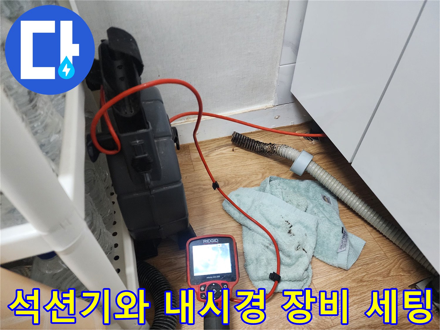 싱크대 하부 배관 점검을 위해 바닥에 놓인 석션기 및 내시경 모니터