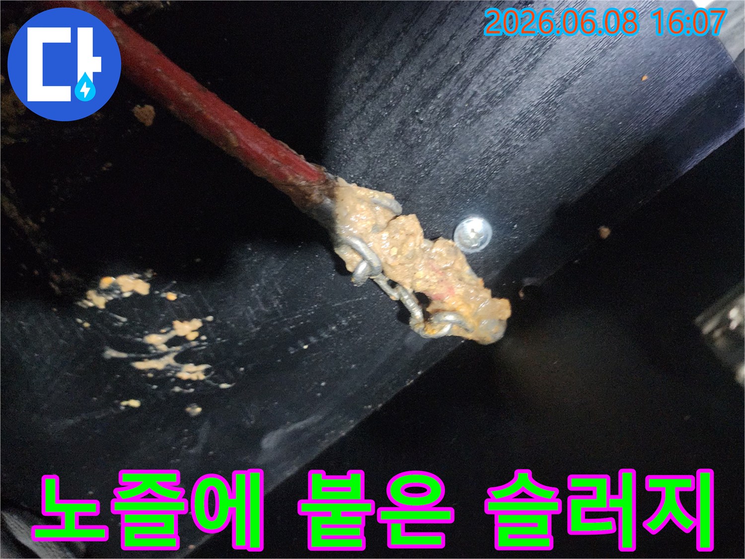 배관 스케일링 작업 중-노즐 끝에 가득 묻어 나온 붉은색 슬러지 모습