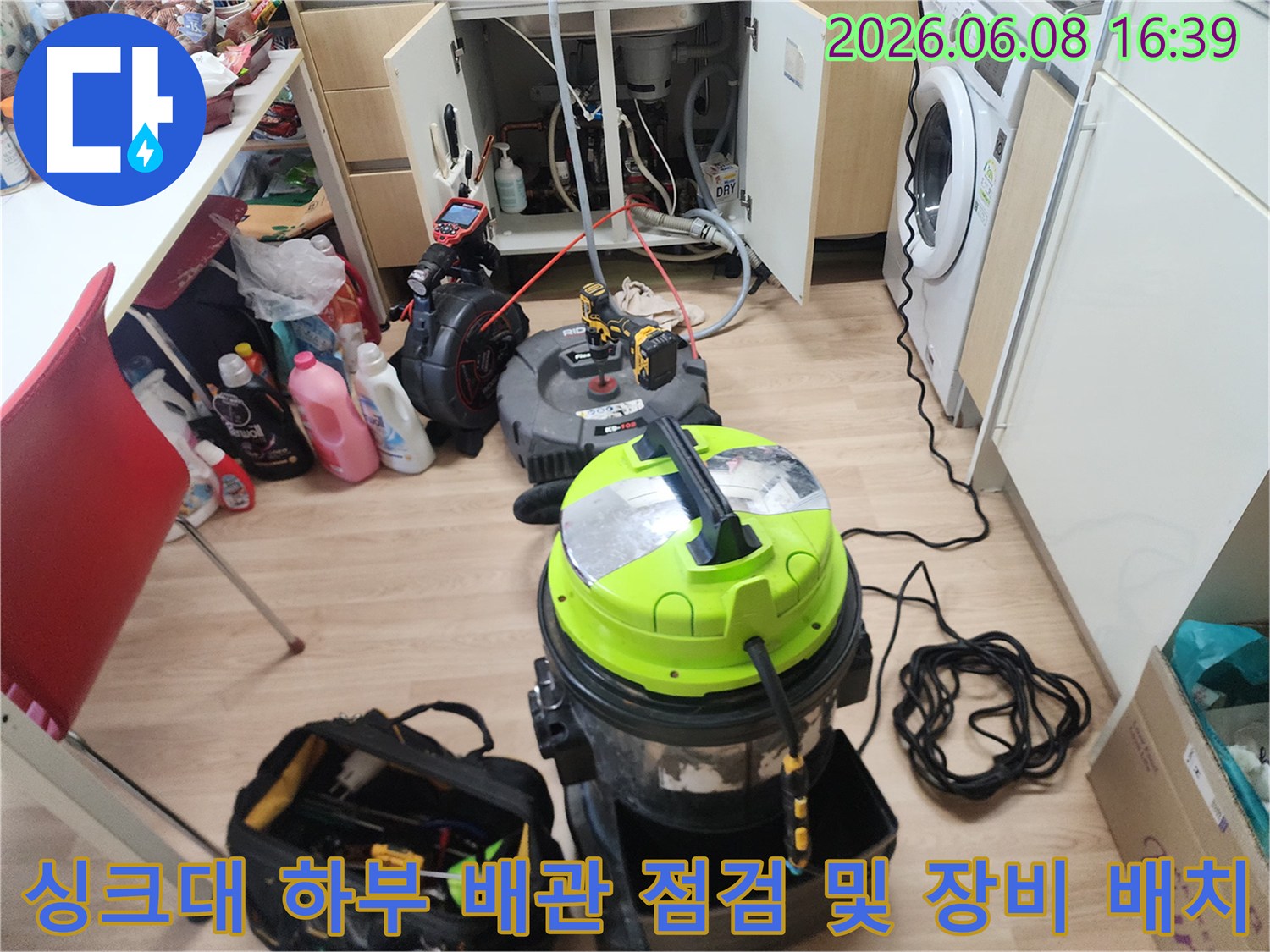 싱크대 아래쪽 좁은 공간에서 배관 막힘을 해결하기 위해 장비를 세팅한 사진입니다.