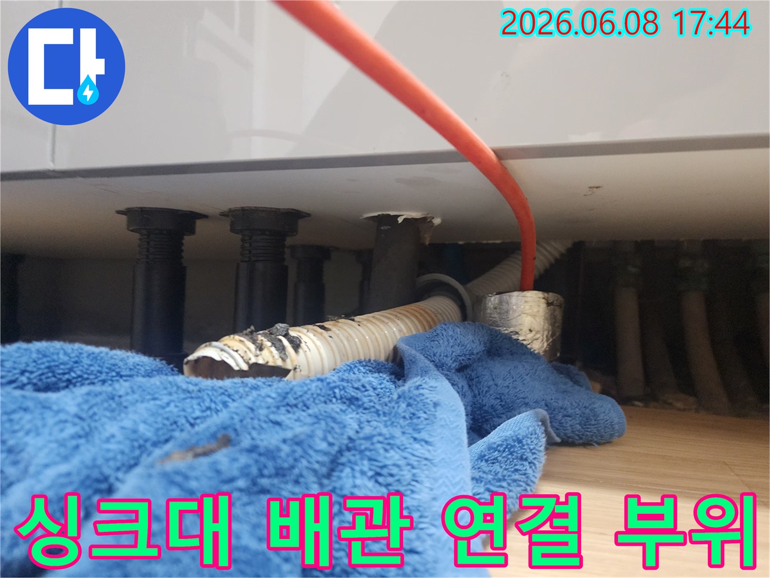 싱크대 하부장 아래-노출된 검은색 배관들과 분리된 주름관