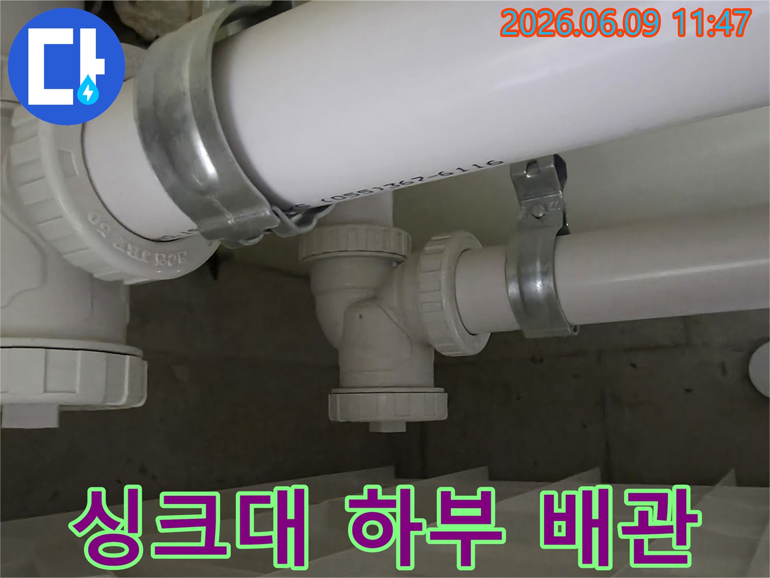 싱크대 하부 배관의 연결 부위를-전문가가 세밀하게 점검하며-누수 여부를 확인하는 모습입니다