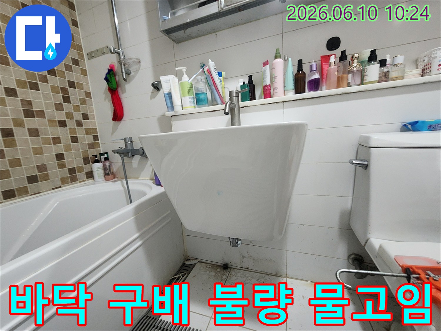 욕실 바닥의 물고임과-오염된 타일을 통해-구배 불량으로 인한-누수 가능성을-보여주는 현장 사진입니다