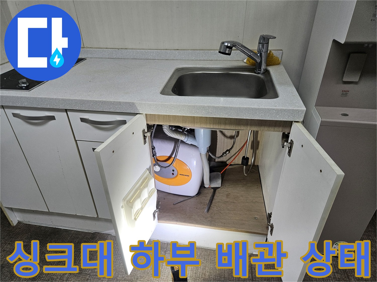 주방 싱크대 하부장 내부의 세탁기 배관과 수도 연결 부위 점검 모습