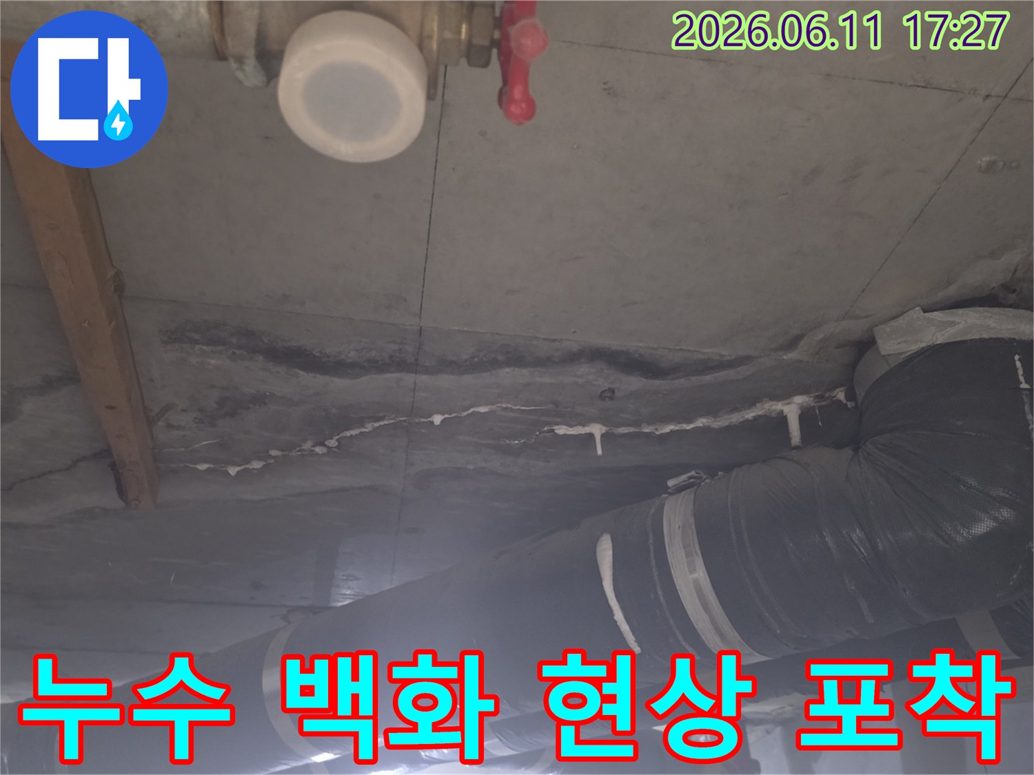 누수로 인해 콘크리트 표면에 형성된 흰색 침전물과 아래쪽 배관의 상태를 상세히 담고 있습니다