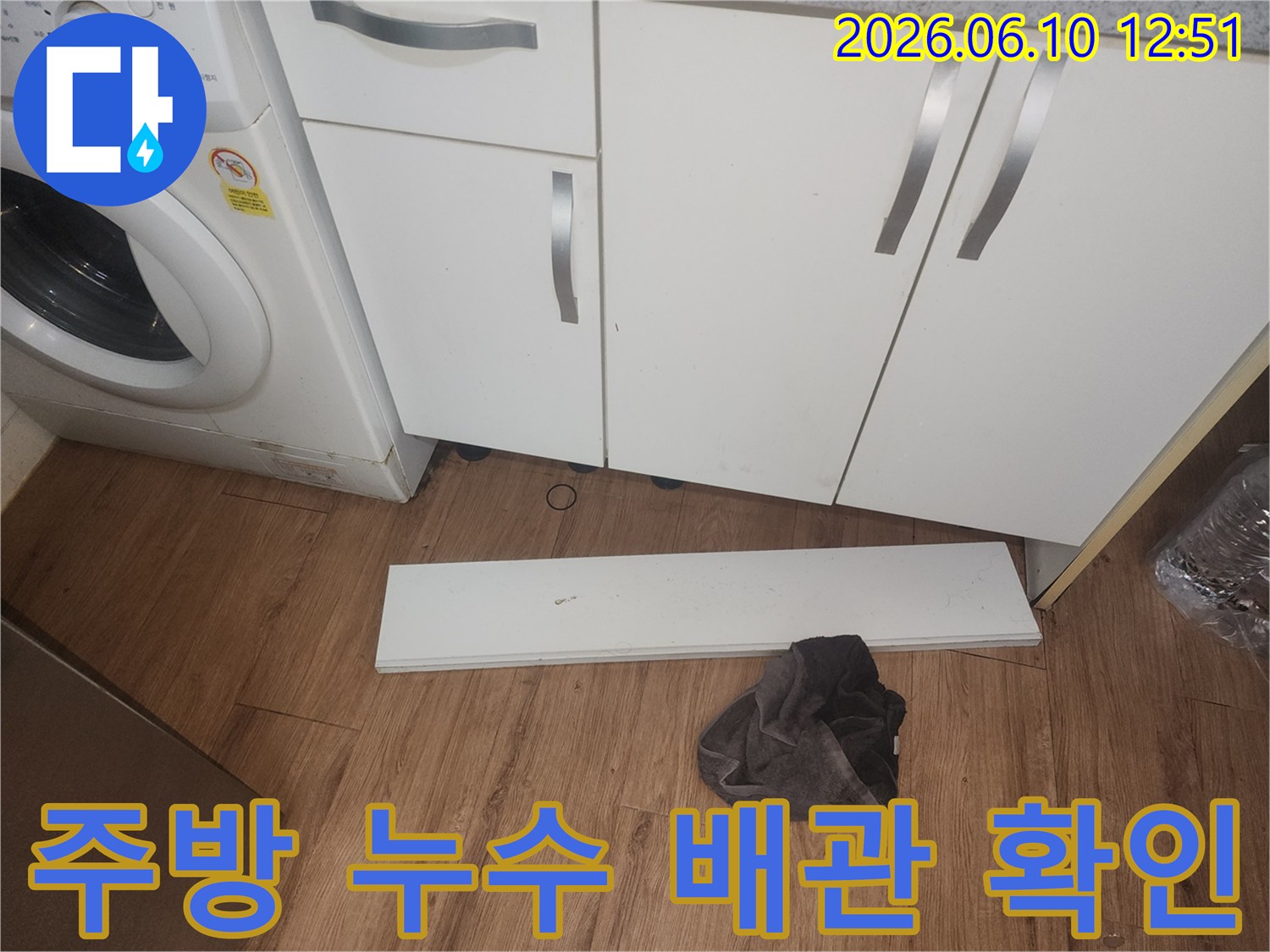 주방-누수-조사를-위해-싱크대-하부-걸레받이를-제거하고-내부-배관-상태를-점검하는-사진입니다