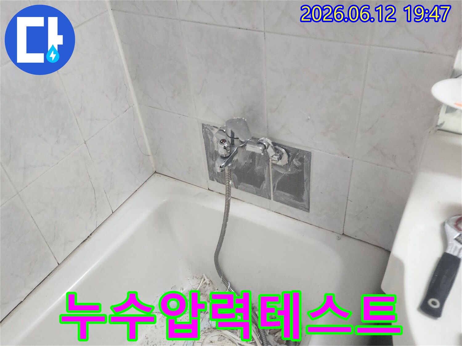 욕실 배관 수리 후 누수 여부를 최종 확인하기 위해 압력 테스트 장비를 연결하고 점검하는 모습 - 완벽한 해결을 위한 필수 과정입니다