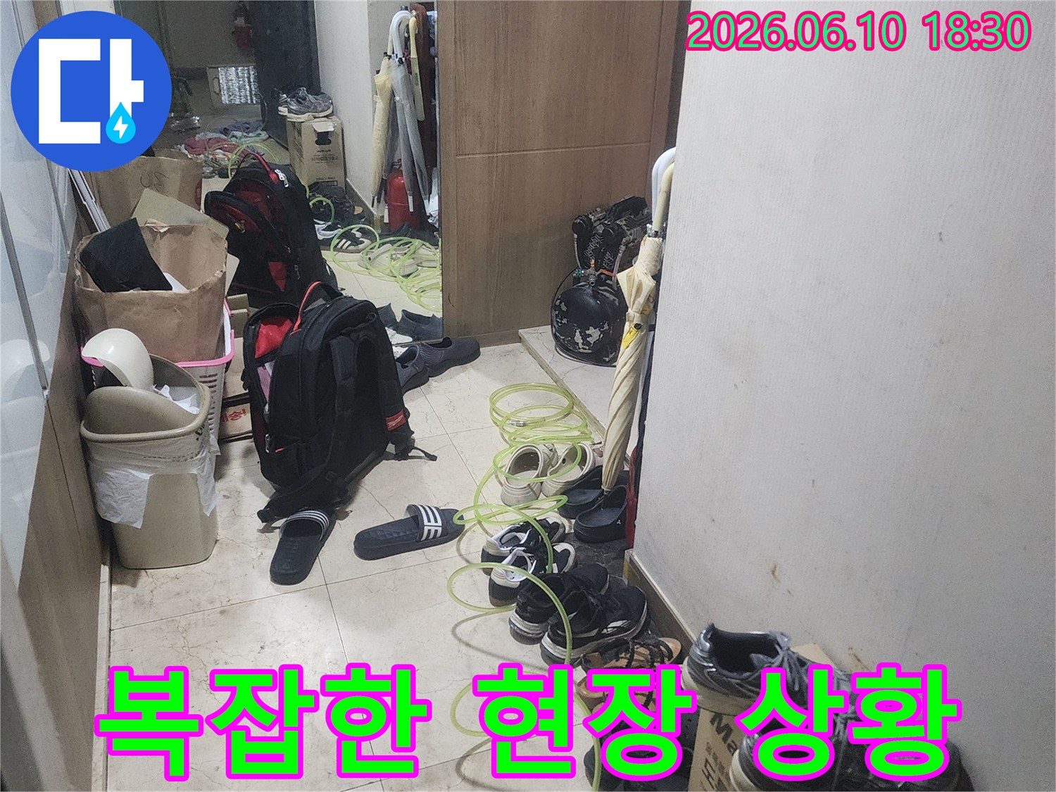 누수 탐지 작업을 위해-현관에 장비를-배치하고 있는-모습을 보여주는-사진입니다.