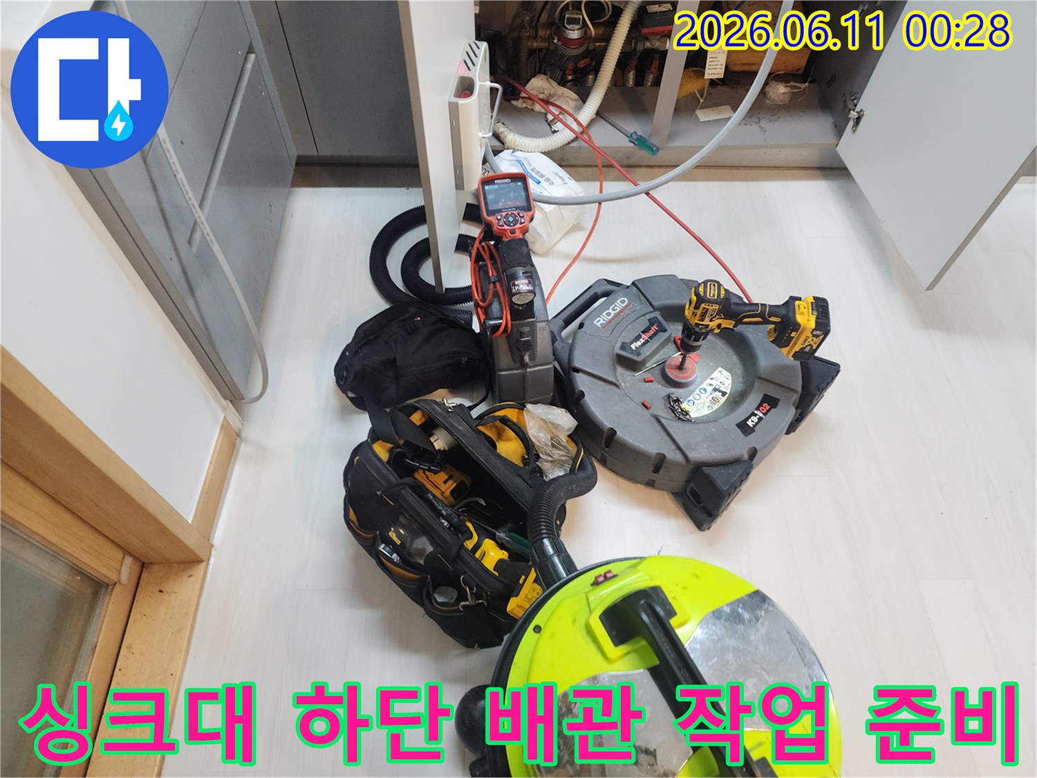 싱크대 아래쪽 좁은 공간에서 진행될 배관 스케일링 및 석션 작업을 위한 장비 배치입니다.