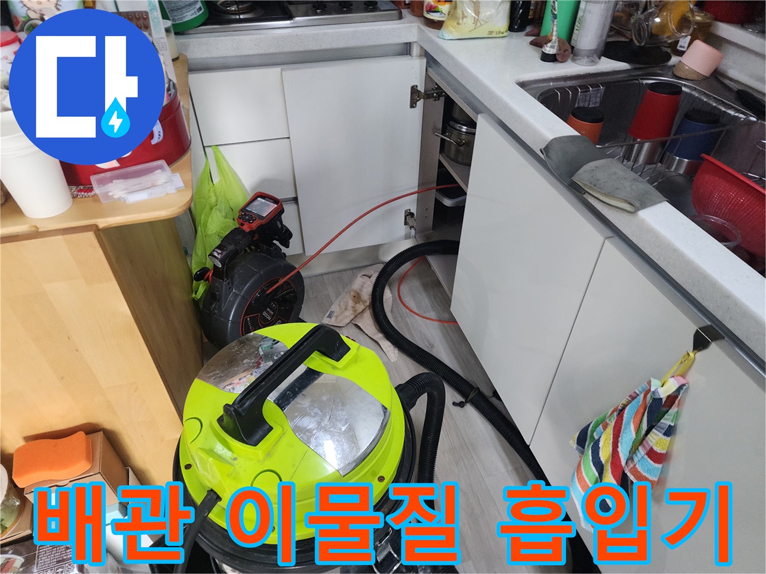 싱크대 하부 배관의 막힌 부분을 해결하기 위해 석션 장비를 가동하는 현장 상황