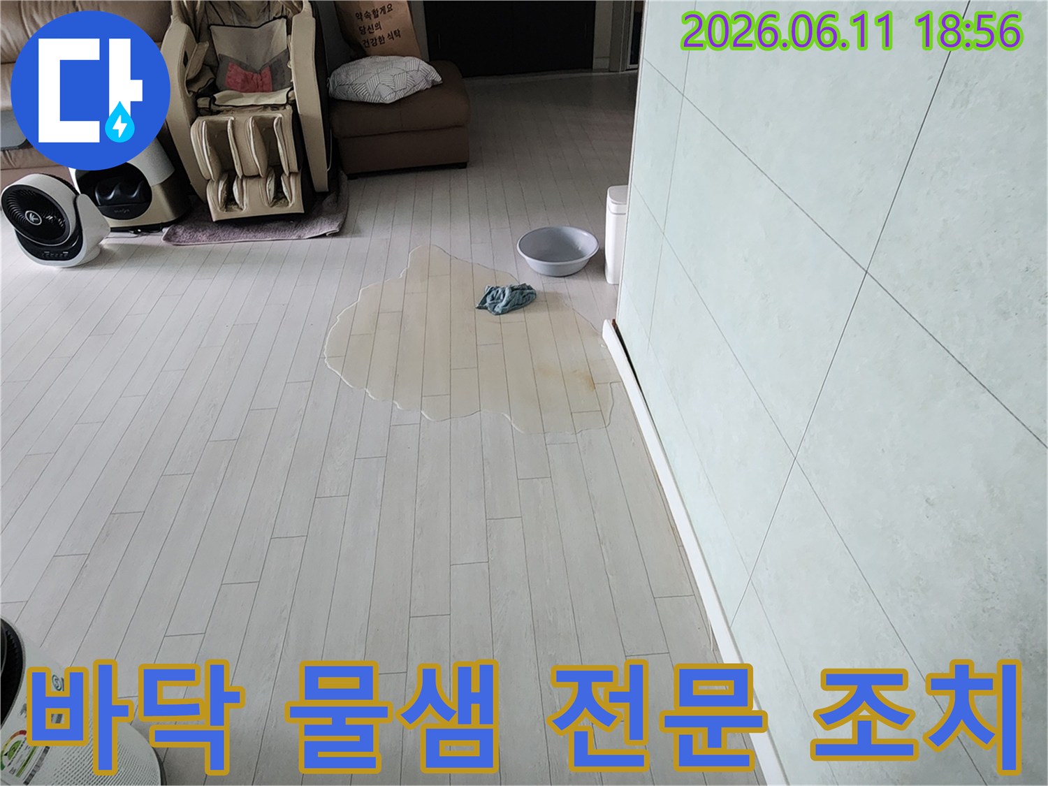 거실 바닥에 물이 고여있는-누수 현장을 보여주며-전문적인 조치가 필요한 상황입니다