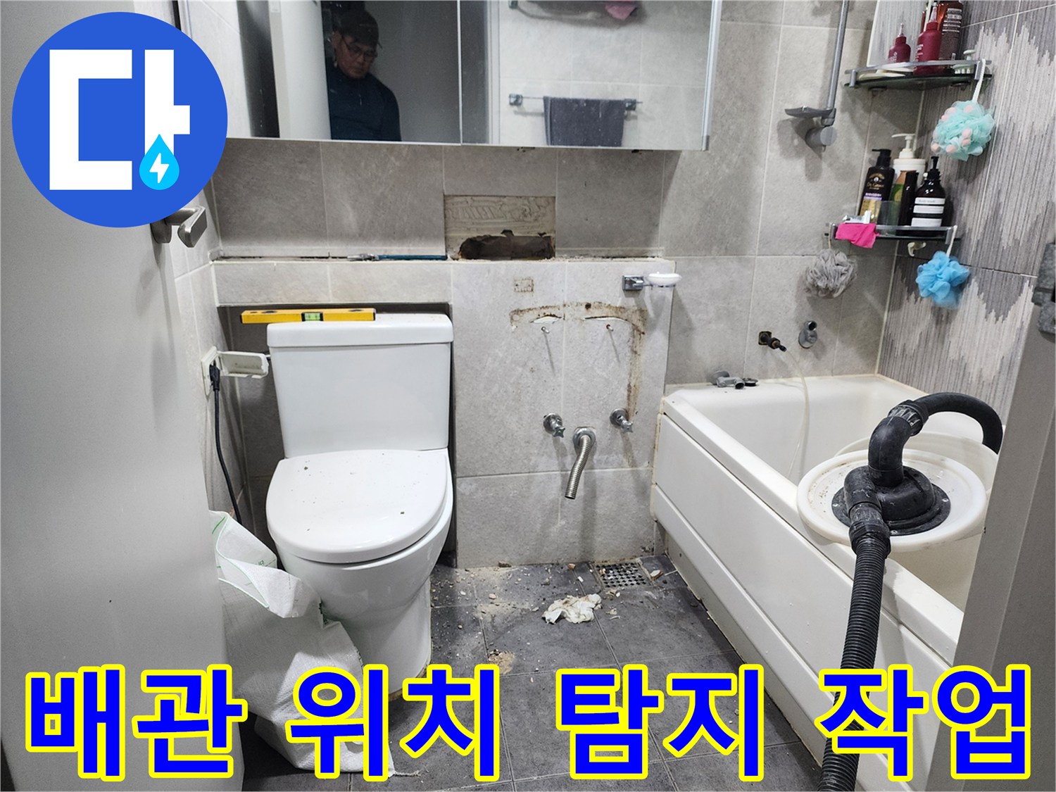 이 이미지는-서울 동대문구의 한 화장실에서-누수 원인인 배관의 정확한 위치를-탐지하기 위해-타일을 제거하고-배관 상태를 점검하는-작업 현장을 보여줍니다