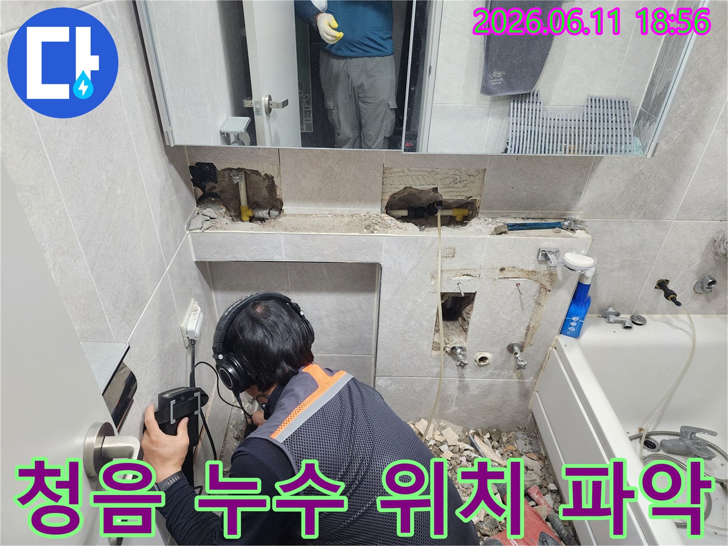 전문 엔지니어가-청음식 누수탐지 장비로-욕실 벽면의-정확한 누수 위치를-세밀하게 파악하는 과정