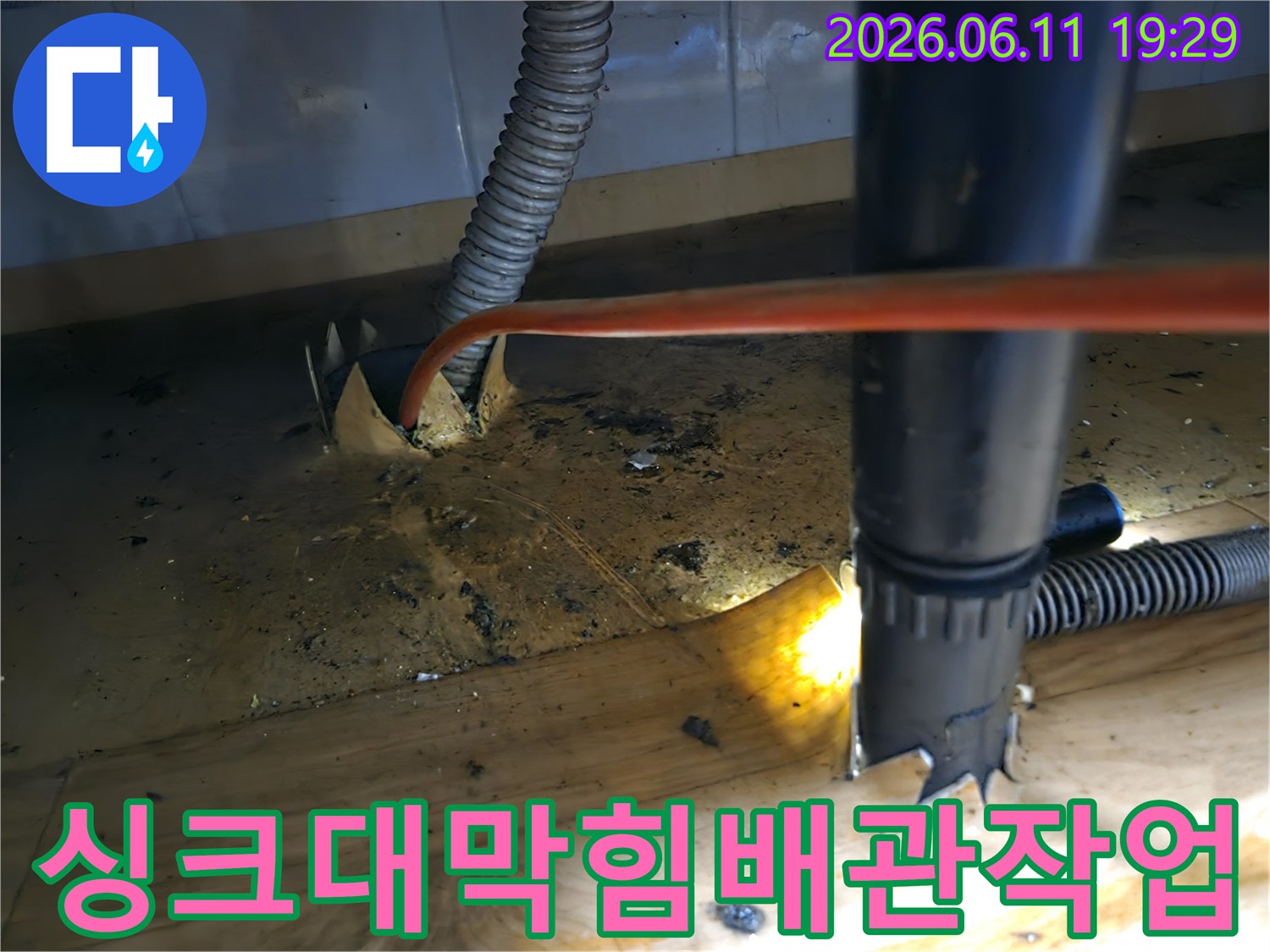 싱크대-배관의-누수와-막힘-문제를-동시에-해결하기-위해-전문가가-샤프트-장비로-배관-내부를-정밀하게-청소하는-작업-현장입니다