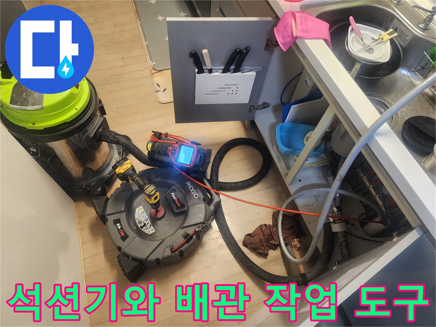 싱크대 하부 배관 작업을 위해 배치된 석션기와 전동 드릴 장비 세트