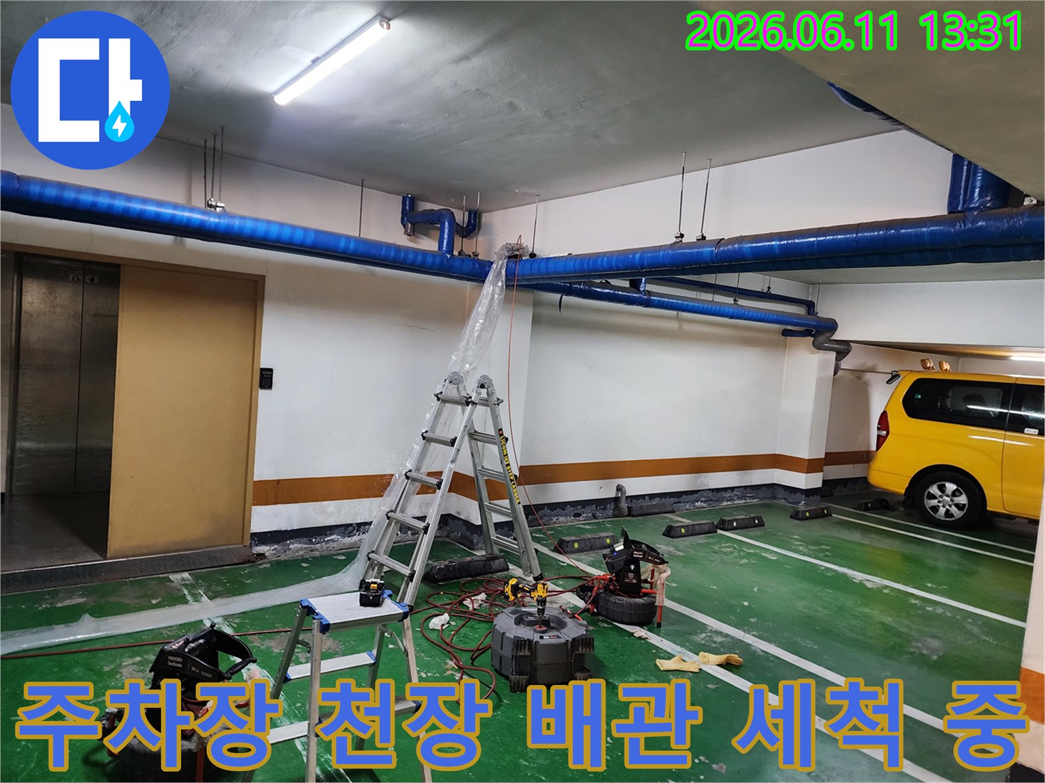 지하주차장 파란색 배관에 고압수를 분사하여 내부를 세척하는 모습입니다.