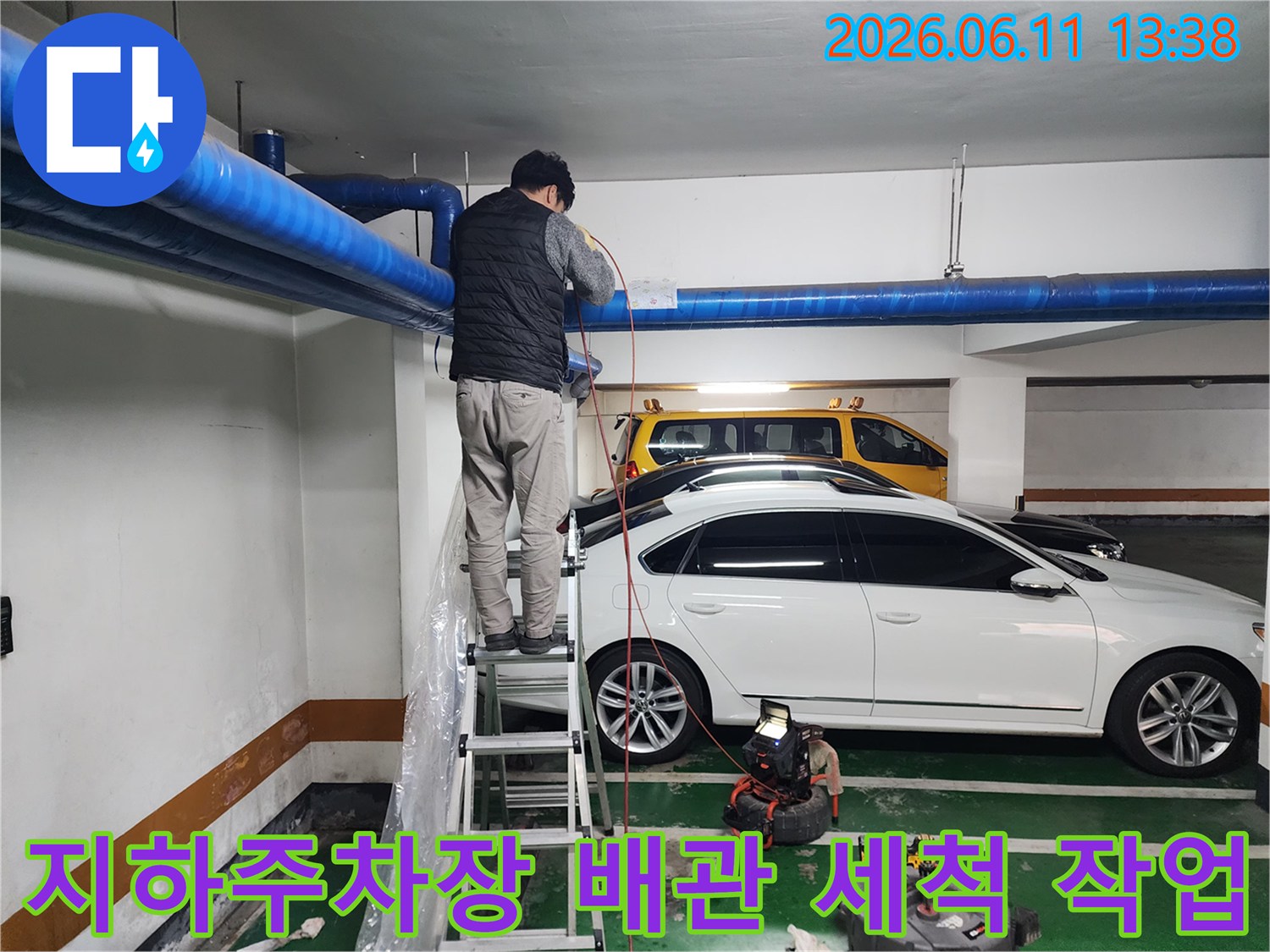 파란색 대형 배관을 대상으로 고압 세척 작업을 진행하는 현장입니다.
