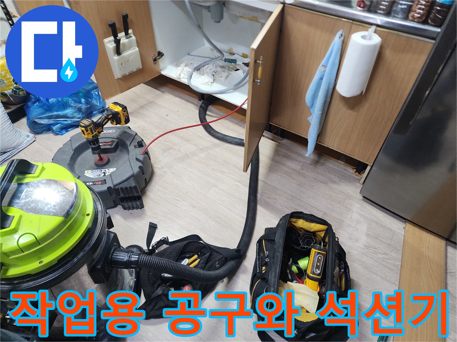 싱크대 하부 배관 작업을 위해 준비된 전문 청소 도구들