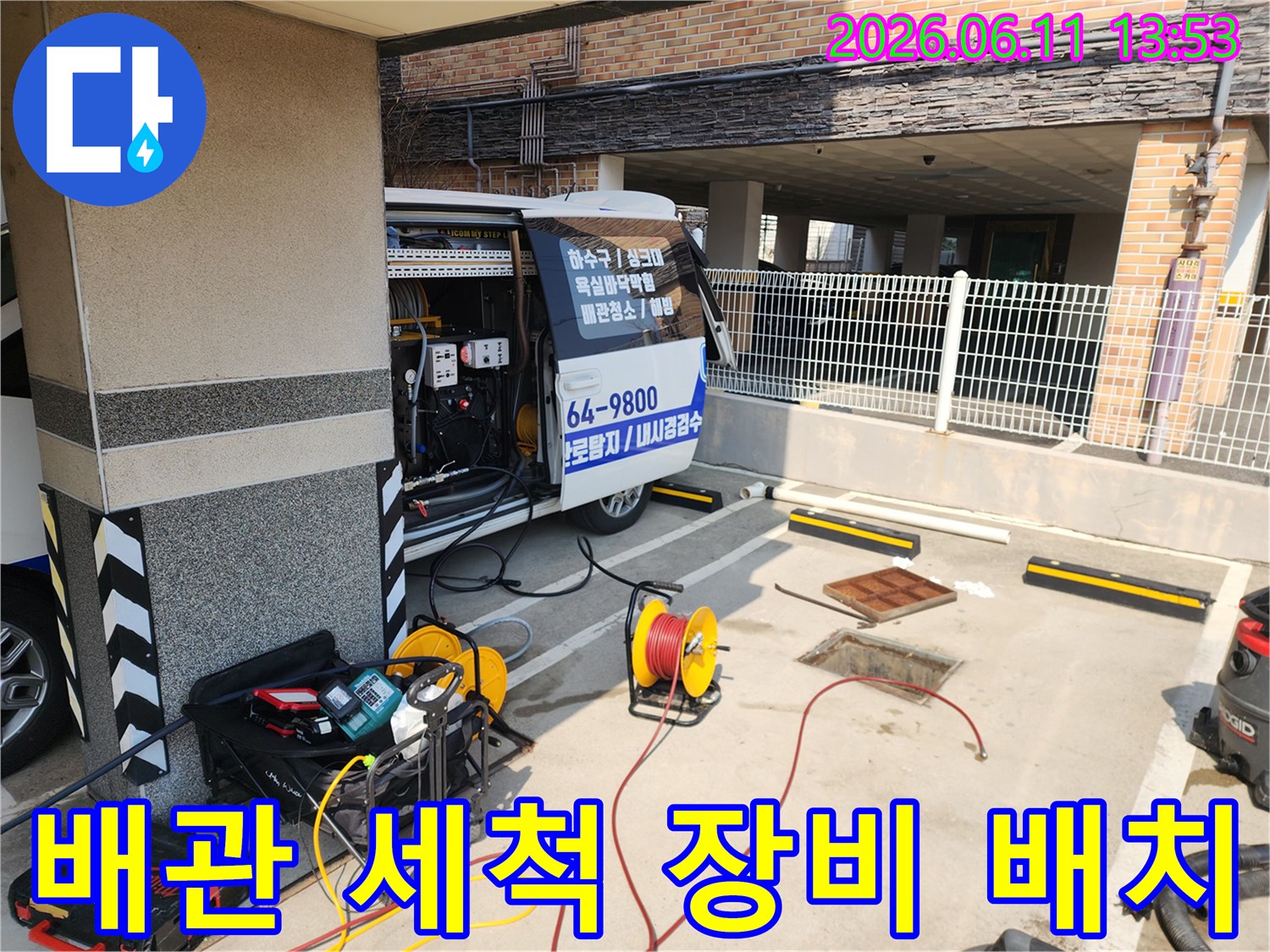 하수구 막힘 해결을 위해 차량에서 꺼내어 정렬한 고압 호스 릴과 작업 도구들입니다.