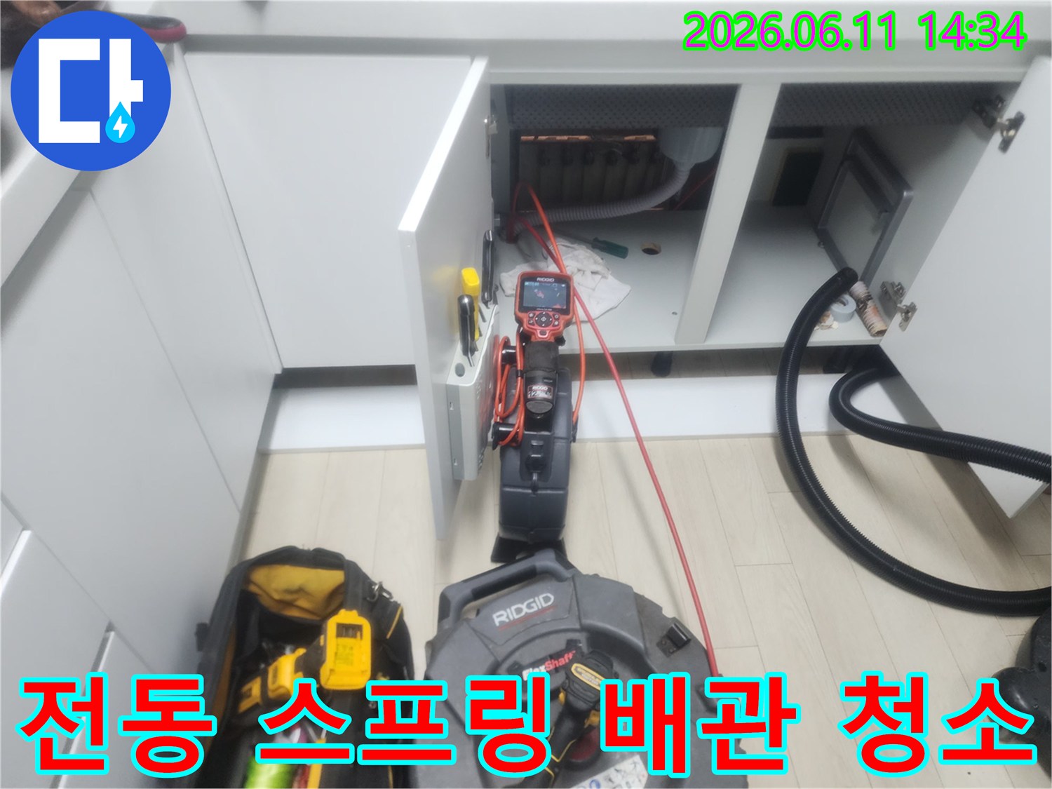 배관 내부의 이물질을 제거하기 위해 전동 장비를 투입하여 작업하는 장면입니다.