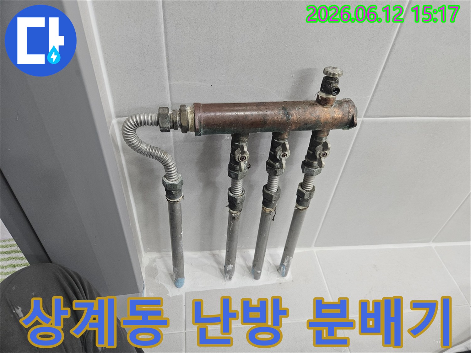 상계동 아파트의 난방 분배기에서 물이 새는 문제가 발생하여-전문 엔지니어가 부식된 배관과 밸브를 면밀히 살피는 모습입니다