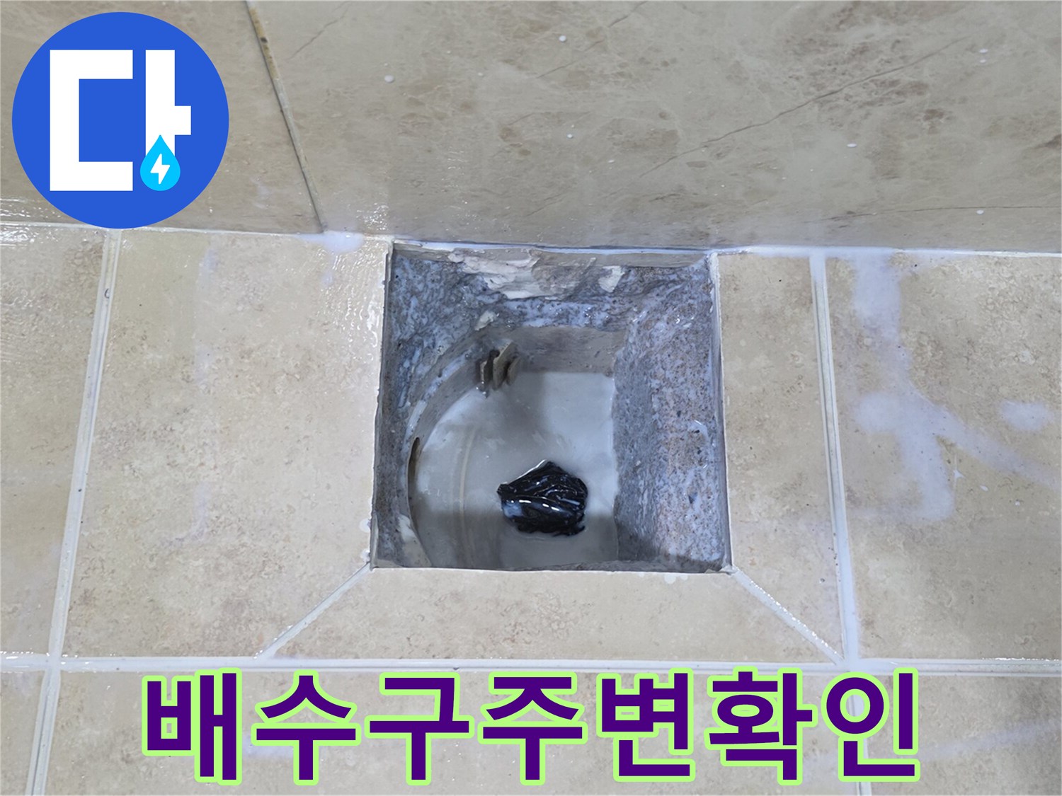 이 이미지는-안양 비산동 아파트의-누수 공사 현장에서-타일 철거 후-배수구 주변을 확인하는 모습입니다