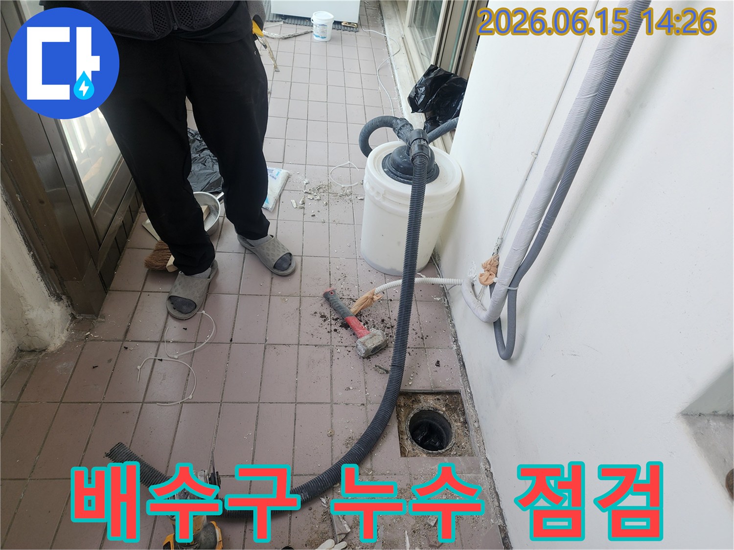 누수 엔지니어가-베란다 배수구 주변의 누수 여부를-정밀하게 점검하고 있습니다