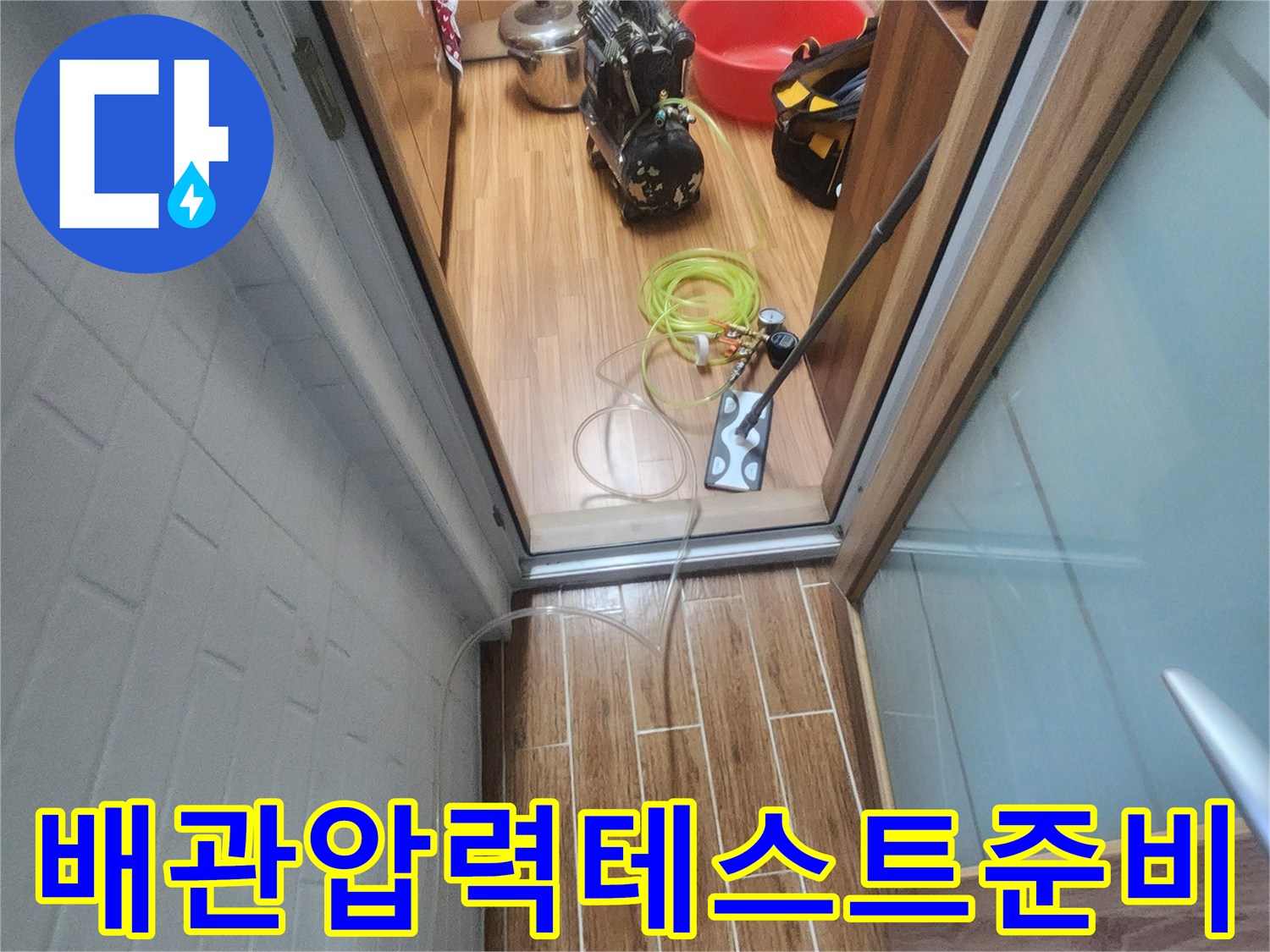 아파트 내부에서 누수 엔지니어가 배관 압력-테스트를 위한 장비 연결을 진행하고 있습니다.