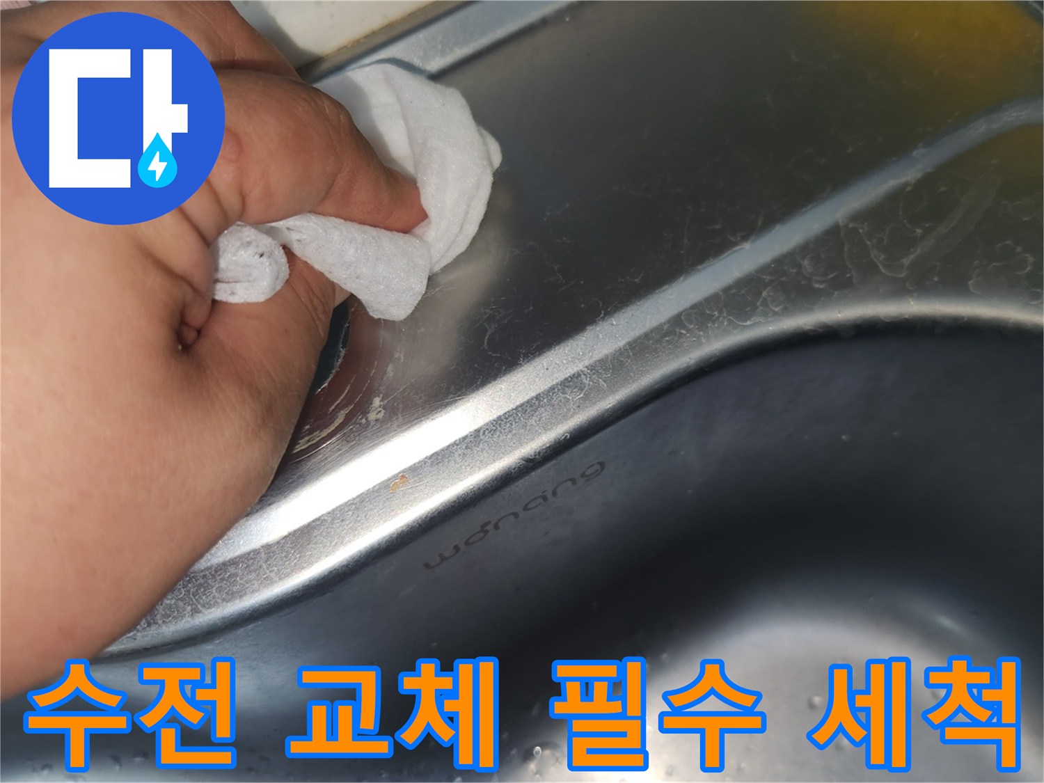 싱크대 상판의 수전 구멍 주변을- 젖은 천으로 꼼꼼히 닦아내며- 세척하는 손의 모습입니다