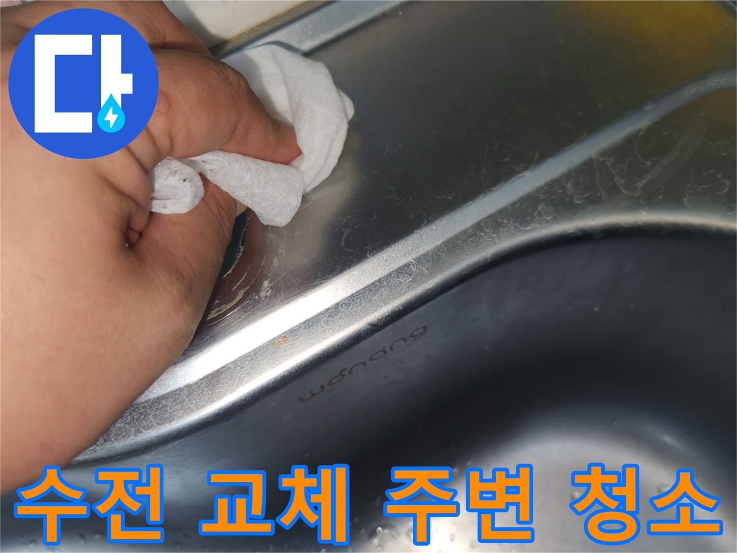 싱크대 상판의 수전 구멍 주변을- 젖은 천으로 꼼꼼히 닦아내며- 청소하는 손의 모습입니다