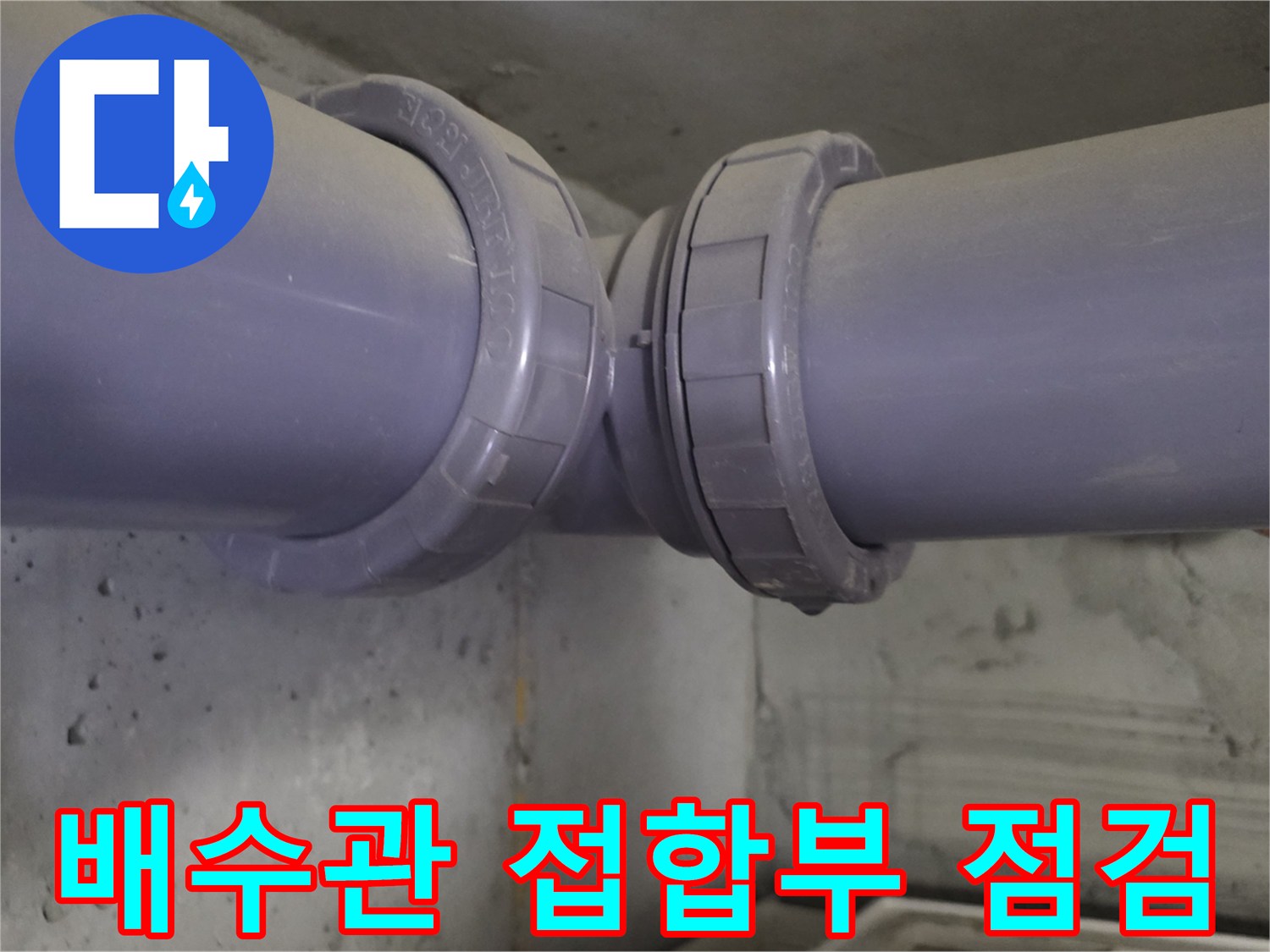 천장에 매달린 배관의 연결 마디를 근접하여 촬영한 모습입니다.