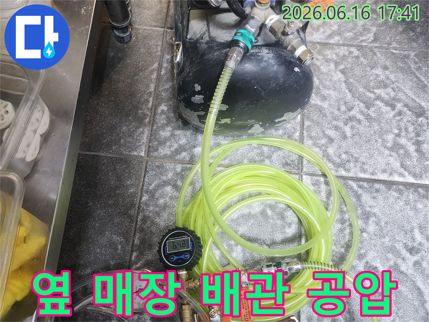 이 사진은 옆 매장의 누수 문제를 해결하기 위해-배관 공압 검사를 진행하는-전문적인 과정을 보여줍니다