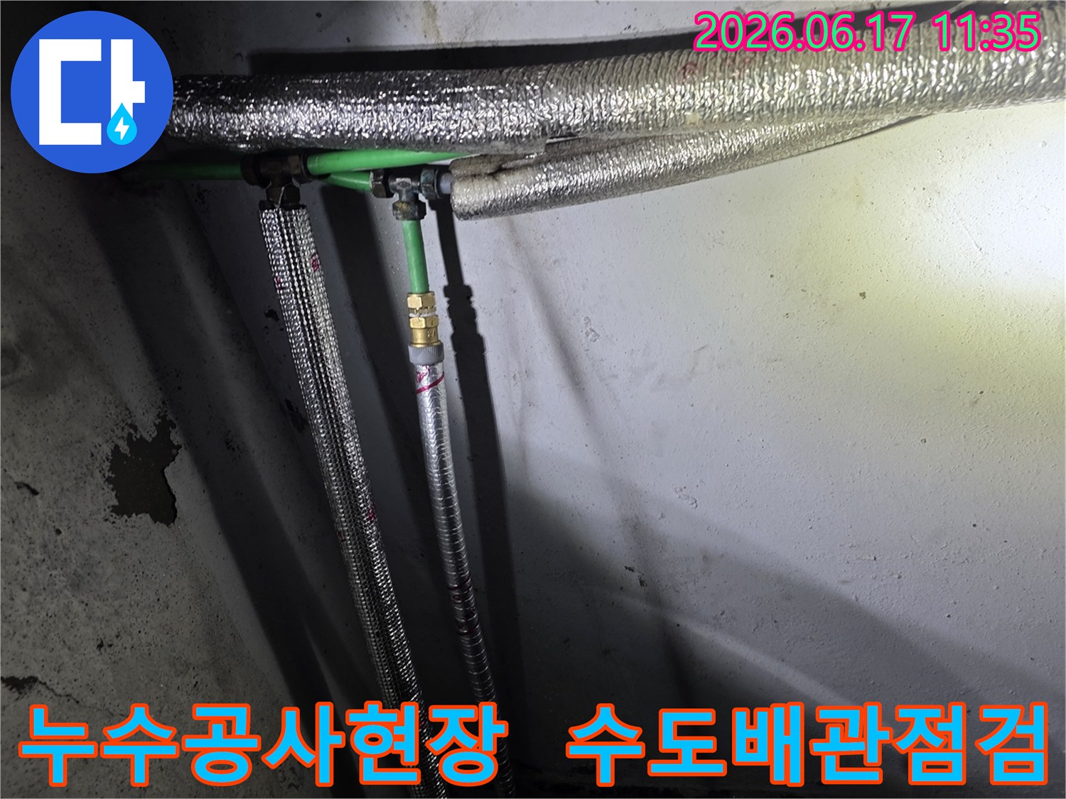 누수 공사 현장에서-발견된-녹색 배관과-은색 보온재로 감싸인-수도관 연결부의 모습