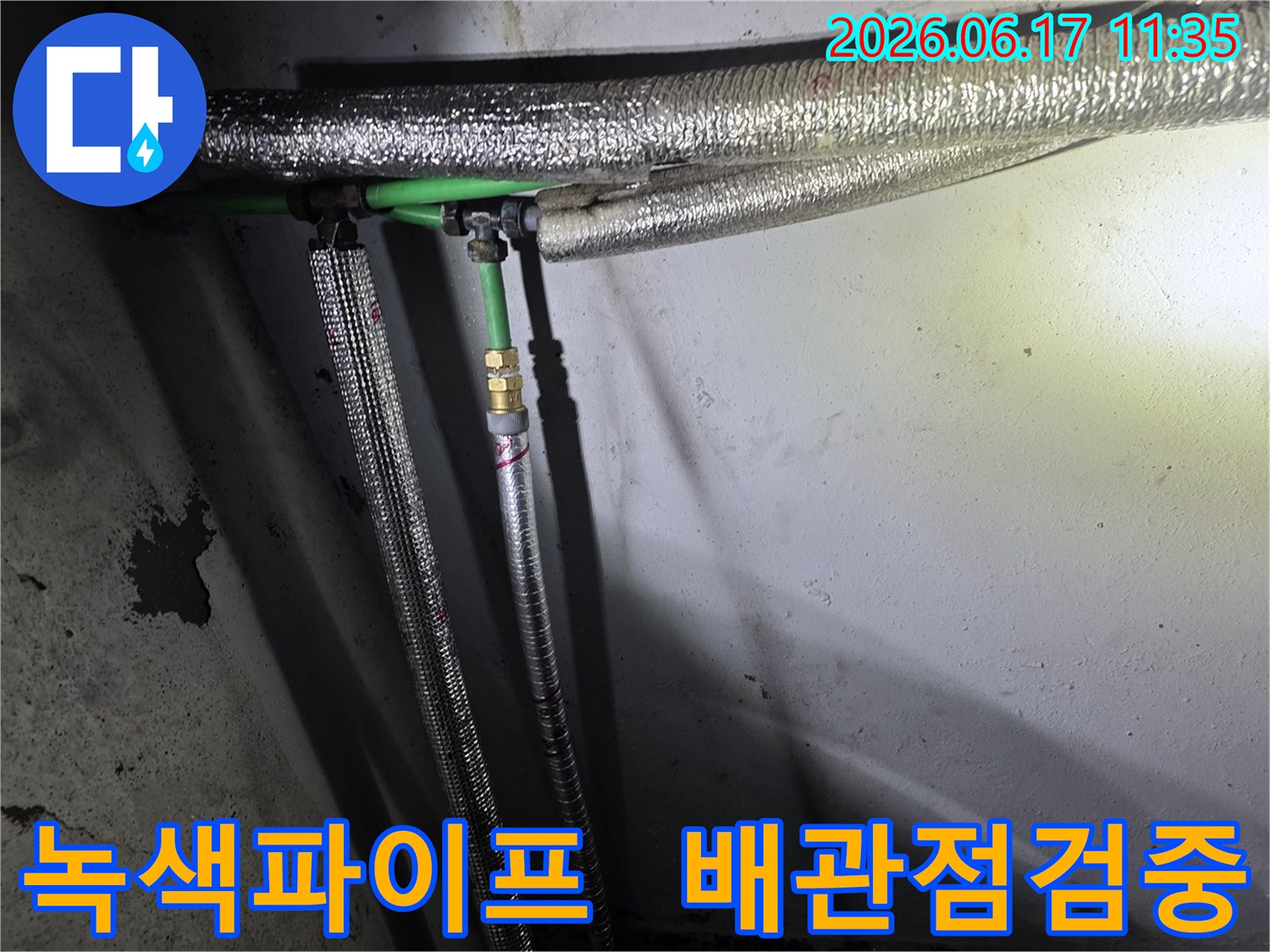 누수 공사 현장에서-발견된-녹색 배관과-은색 보온재로 감싸인-수도관 연결부의 모습