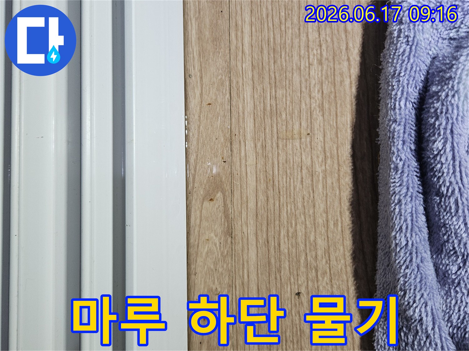 마루 하단부에 물기가 스며들어 젖어 있는 상태를 보여주는 누수 현장 사진
